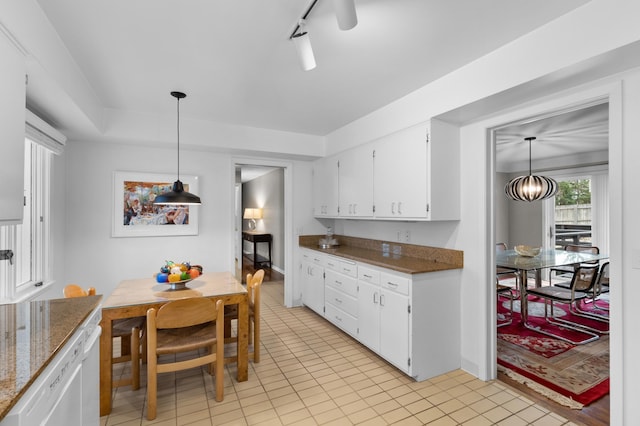 kitchen featuring light tile patterned floors, stone countertops, white cabinetry, and decorative light fixtures