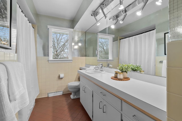 bathroom featuring plenty of natural light, tile patterned floors, toilet, and tile walls
