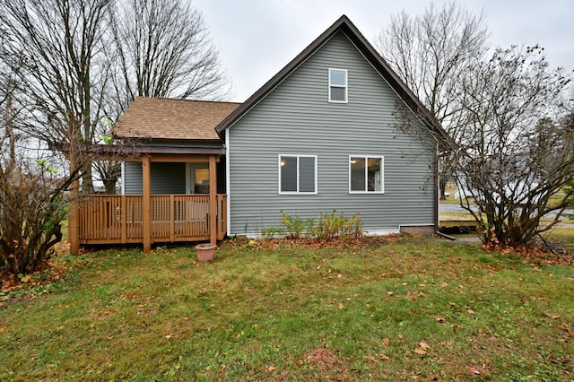 rear view of house with a deck and a yard