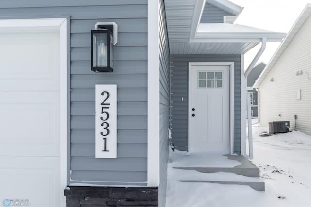 snow covered property entrance featuring cooling unit