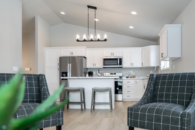 kitchen with decorative light fixtures, white cabinetry, and appliances with stainless steel finishes