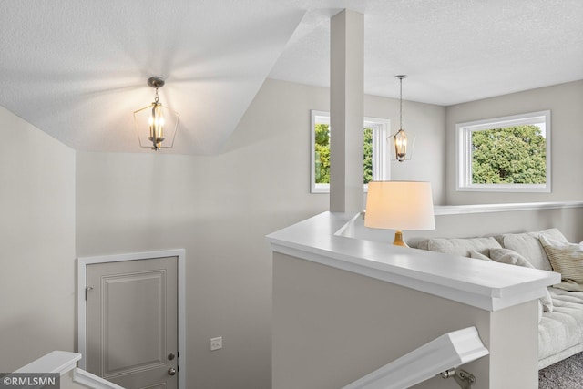 stairway featuring lofted ceiling and a textured ceiling