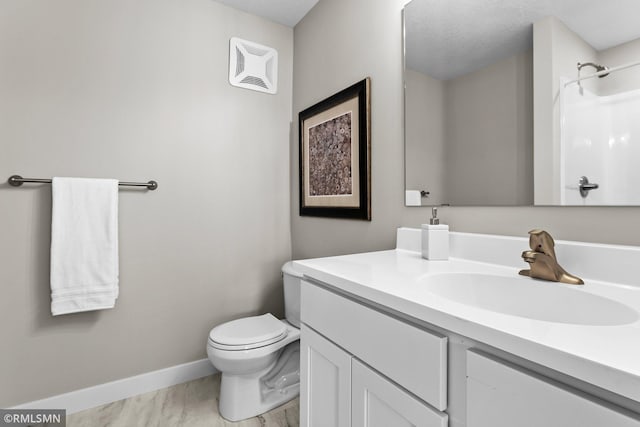 bathroom featuring vanity, toilet, and a shower