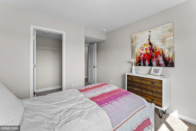 carpeted bedroom featuring a closet and a spacious closet