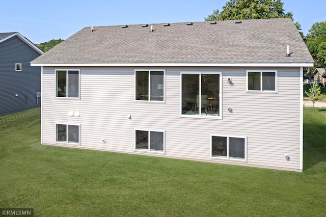 rear view of house featuring a lawn