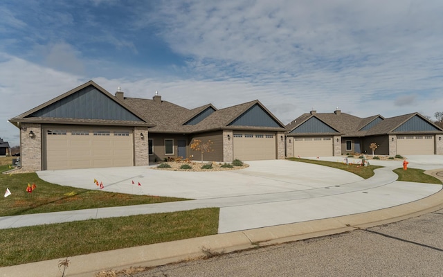 885 Picadilly Ln NW, Rochester, MN 55901 - view of front of house with brick siding, a chimney, driveway, and a garage