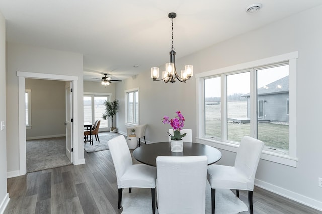 dining room featuring an inviting chandelier, visible vents, baseboards, and dark wood-style flooring