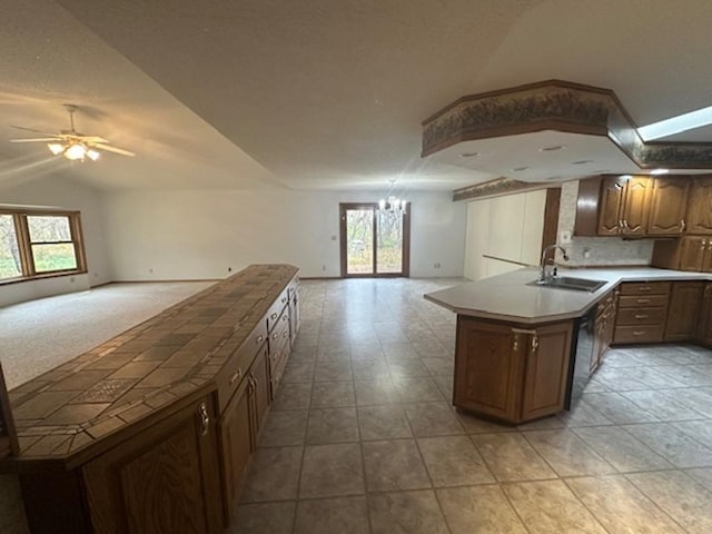 kitchen featuring sink, a center island, ceiling fan with notable chandelier, and plenty of natural light