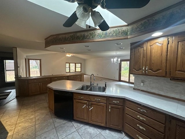 kitchen featuring kitchen peninsula, light tile patterned floors, dishwasher, ceiling fan with notable chandelier, and sink