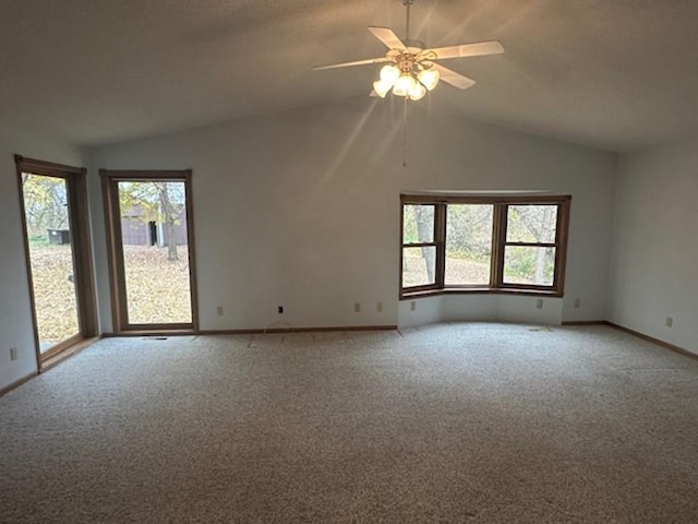 carpeted spare room featuring ceiling fan and vaulted ceiling