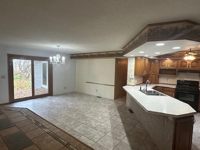 kitchen with black range with gas cooktop, a textured ceiling, sink, and ceiling fan with notable chandelier