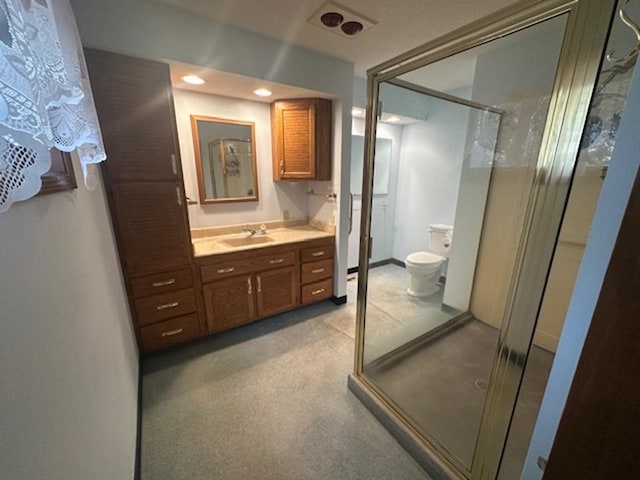 bathroom featuring vanity, toilet, and walk in shower