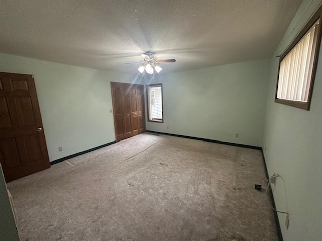 empty room with light carpet, a textured ceiling, and ceiling fan