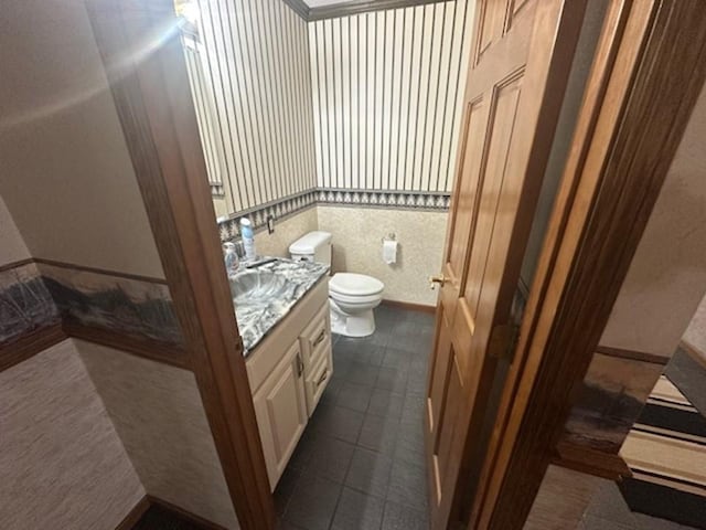 bathroom featuring toilet, vanity, and tile patterned flooring