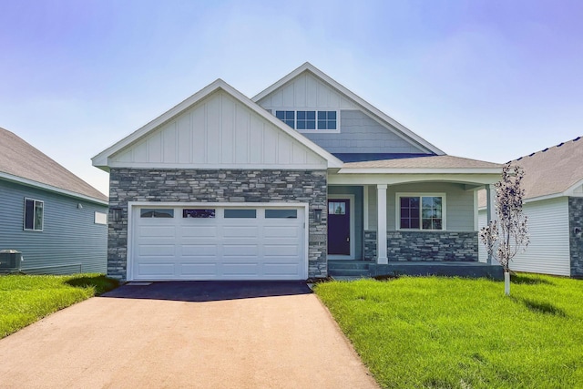 craftsman-style home with a porch, a front yard, and a garage