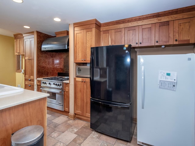 kitchen featuring decorative backsplash, black refrigerator, range hood, high end range, and white fridge