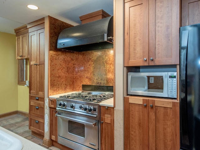 kitchen with appliances with stainless steel finishes, range hood, and tasteful backsplash