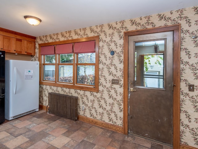 kitchen with white fridge and radiator