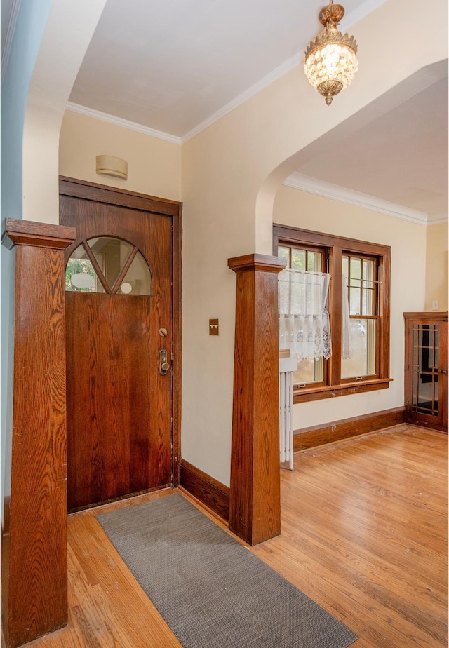 foyer entrance featuring ornamental molding and light hardwood / wood-style flooring