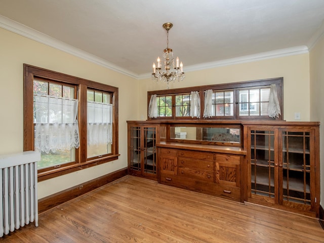 dining room featuring light hardwood / wood-style floors, crown molding, and a healthy amount of sunlight