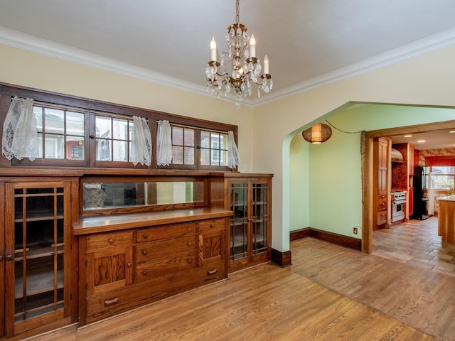 dining area featuring crown molding, a chandelier, and light wood-type flooring