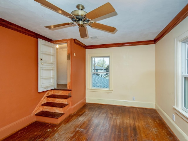 empty room featuring dark wood-type flooring, ceiling fan, and ornamental molding