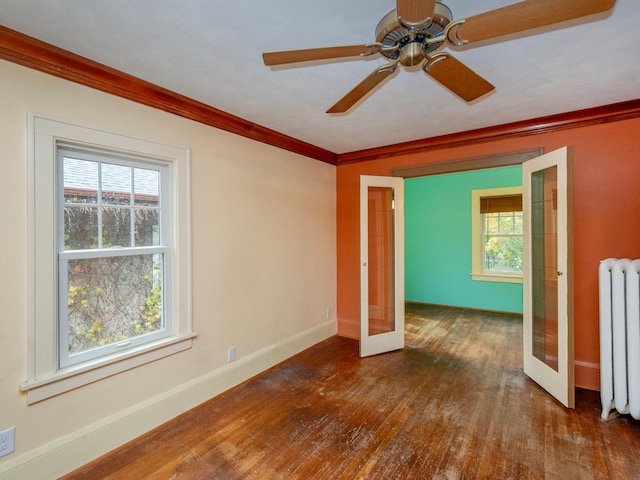 spare room with french doors, radiator heating unit, dark hardwood / wood-style floors, and plenty of natural light