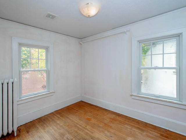 spare room featuring a wealth of natural light, light hardwood / wood-style flooring, and radiator