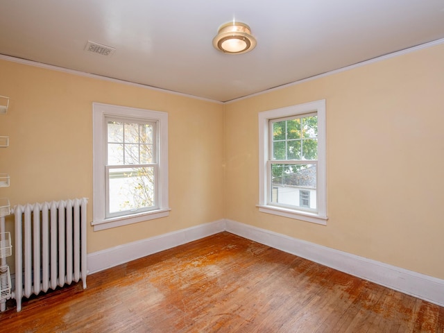 unfurnished room with ornamental molding, light hardwood / wood-style floors, and radiator