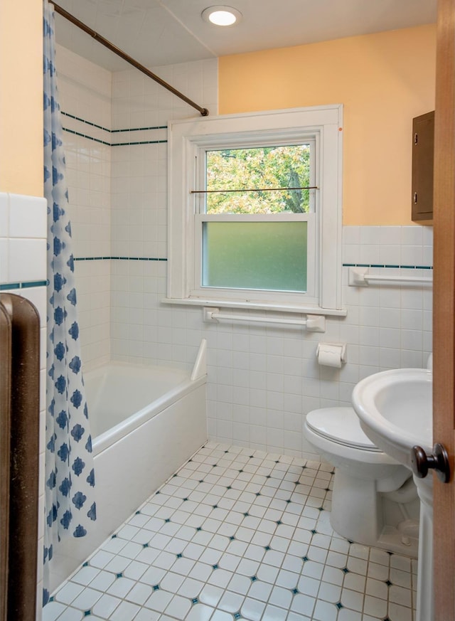 full bathroom with toilet, tile patterned flooring, sink, shower / tub combo with curtain, and tile walls