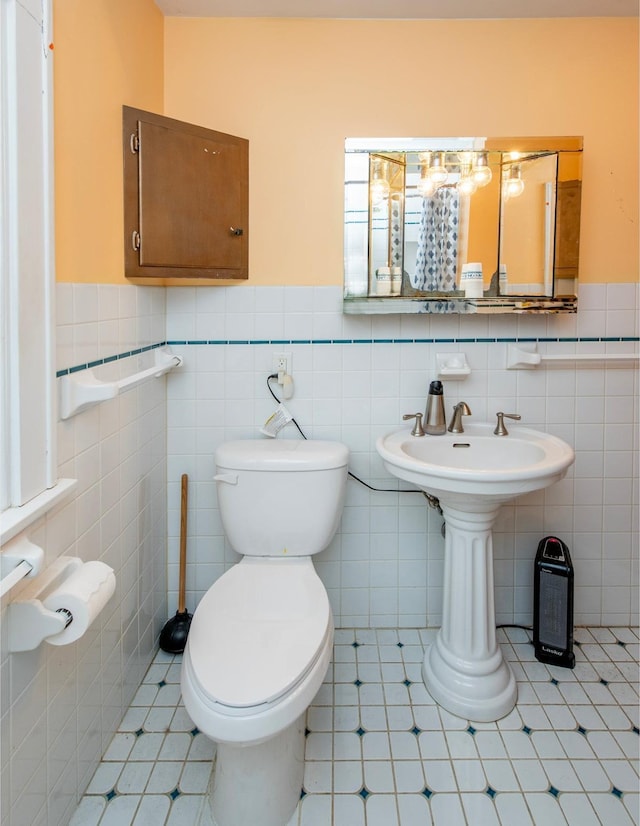 bathroom featuring tile walls and toilet