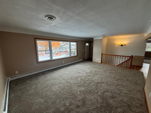 carpeted spare room featuring a textured ceiling and baseboard heating