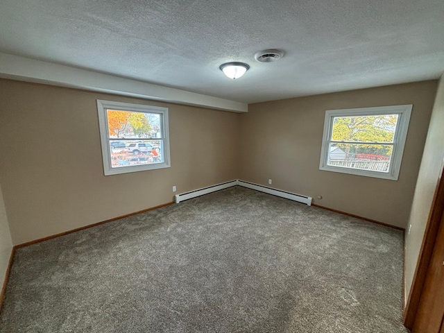 empty room featuring baseboard heating, a textured ceiling, and carpet floors