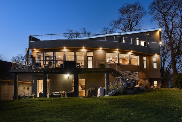 4637 Carlow Rd, Mound, MN 55364 - back of house at twilight with stairs, stucco siding, a balcony, and a yard