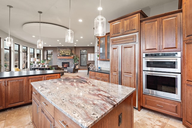 4637 Carlow Rd, Mound, MN 55364 - kitchen with paneled built in fridge, stainless steel double oven, a center island, recessed lighting, and brown cabinetry