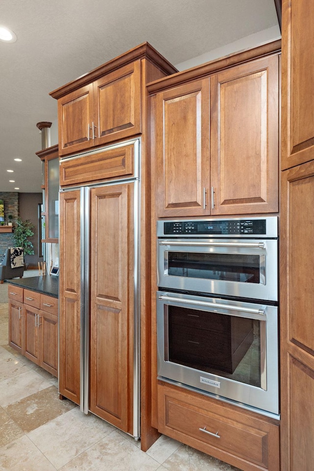 4637 Carlow Rd, Mound, MN 55364 - kitchen featuring double oven, brown cabinetry, paneled fridge, recessed lighting, and dark countertops