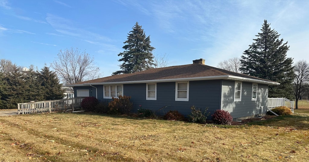 view of home's exterior with a deck and a yard