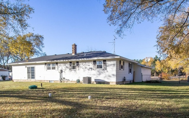 back of house featuring a yard and central AC