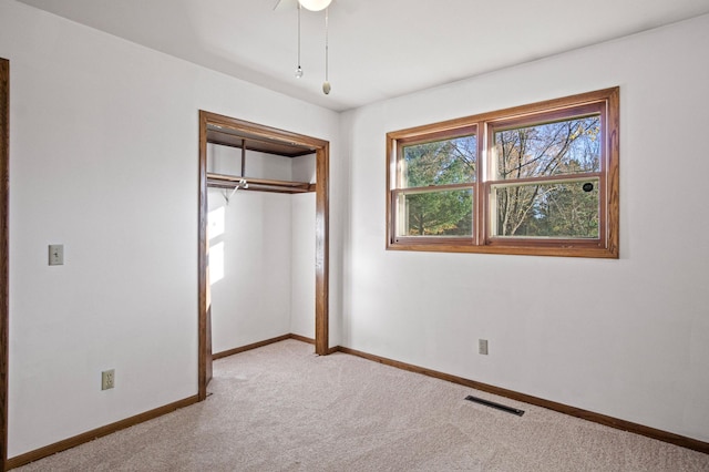 unfurnished bedroom with a closet, ceiling fan, and light colored carpet