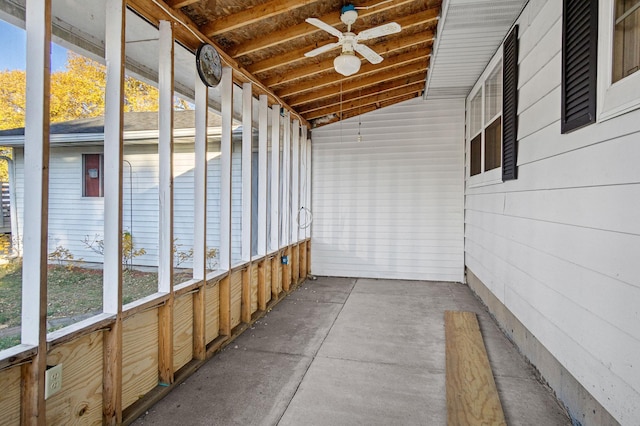 unfurnished sunroom with ceiling fan, a wealth of natural light, and vaulted ceiling