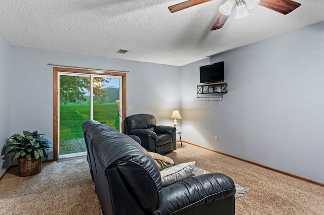 carpeted living room featuring a textured ceiling and ceiling fan