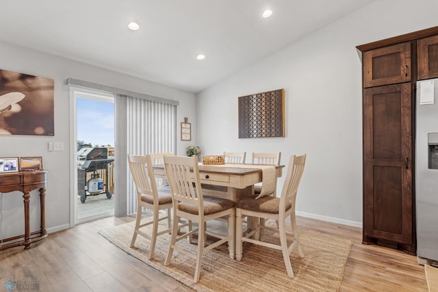 dining space featuring lofted ceiling and light wood-type flooring