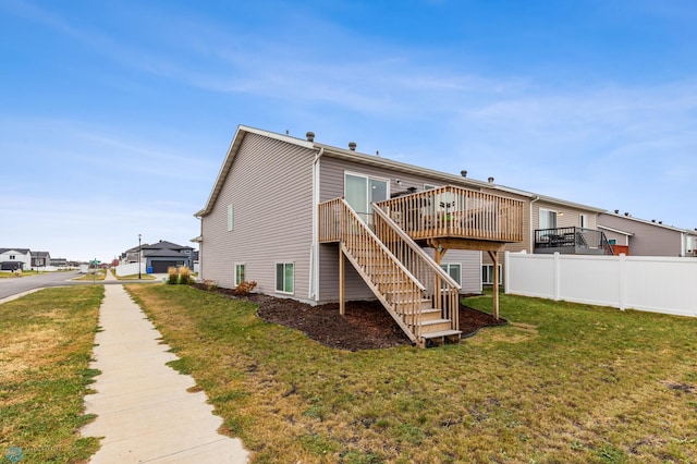 rear view of house featuring a deck and a lawn