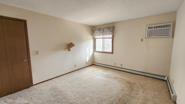 carpeted spare room with baseboard heating, baseboards, a textured ceiling, and a wall unit AC