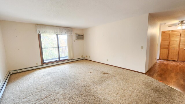 carpeted spare room with a wall mounted air conditioner, a baseboard radiator, baseboards, and ceiling fan