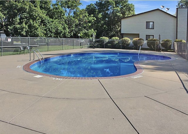 pool with a patio and fence