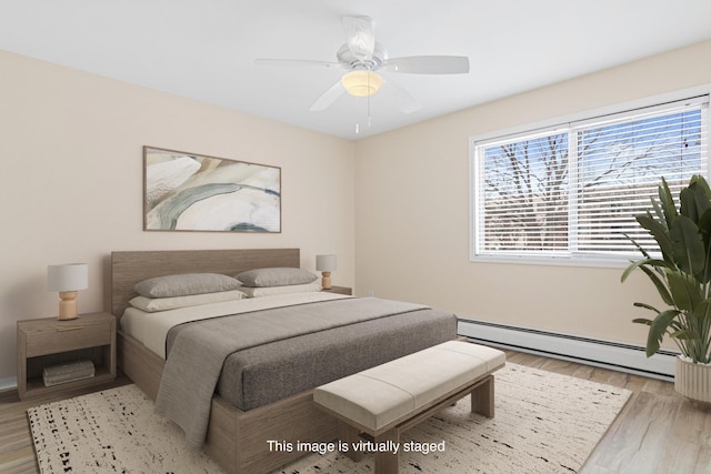 bedroom featuring ceiling fan, light wood-style flooring, and a baseboard radiator