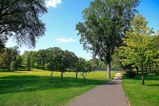 view of community featuring a lawn and fence