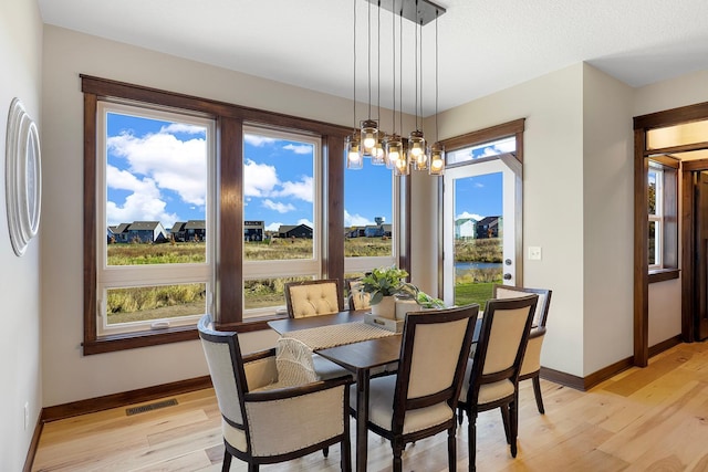 dining area featuring light hardwood / wood-style flooring and an inviting chandelier