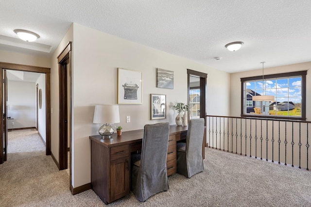 office area with a notable chandelier, a textured ceiling, and light colored carpet